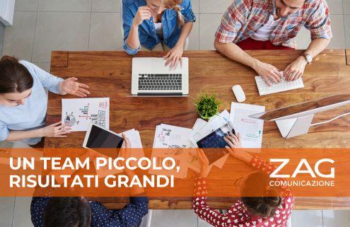 Team di lavoro impegnato a un tavolo con computer portatili e documenti